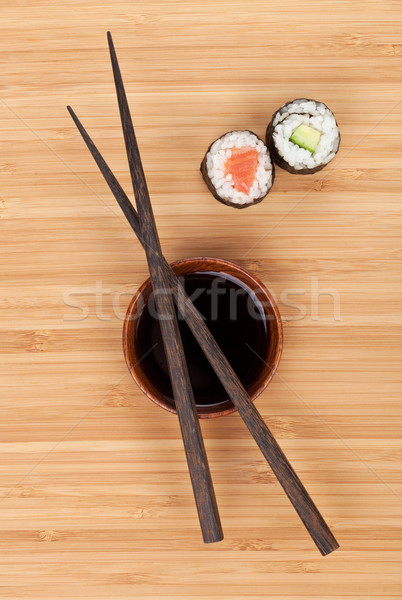 Maki sushi palillos salsa de soja bambú mesa de madera Foto stock © karandaev