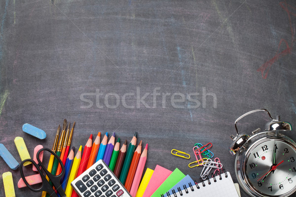 Stock photo: School supplies on blackboard background