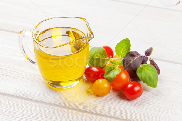 Olive oil, tomatoes, basil on wooden table Stock photo © karandaev
