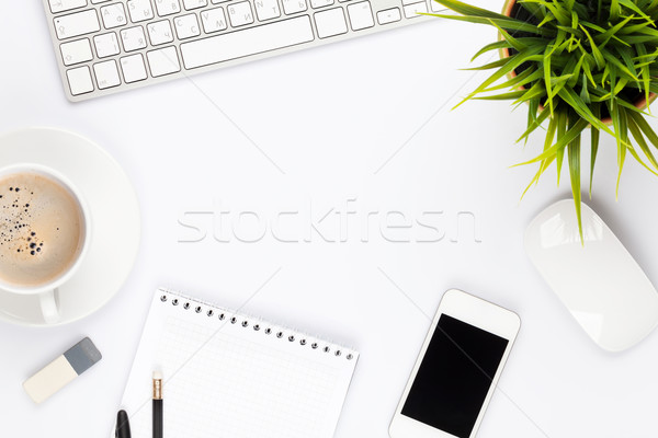 Stock photo: Office desk table with computer, supplies, flower and coffee cup