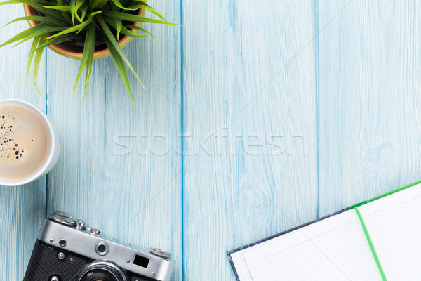 Office desk with notepad, camera, coffee and flower Stock photo © karandaev