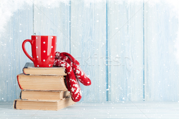 Hot chocolate cup and mittens over books Stock photo © karandaev