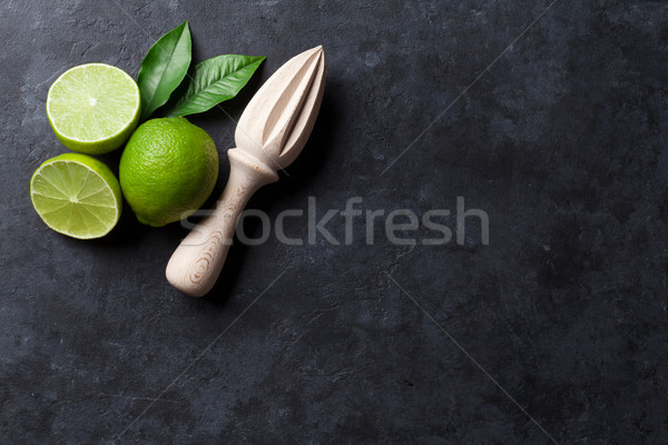 Limes and juicer Stock photo © karandaev