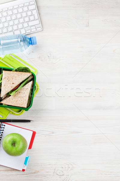 Office desk with supplies and lunch box Stock photo © karandaev