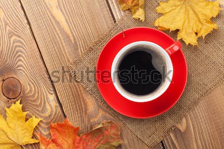 Autumn leaves and coffee cup over wood background Stock photo © karandaev