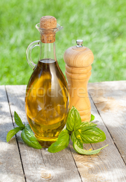 Ulei de măsline sticlă piper shaker busuioc masa de lemn Imagine de stoc © karandaev