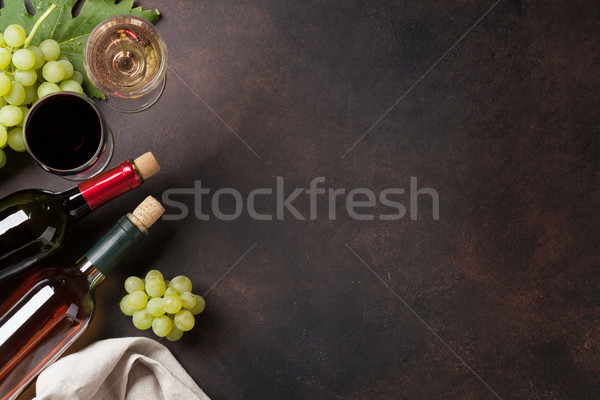 Foto stock: Vinho · garrafas · uvas · pedra · tabela · topo