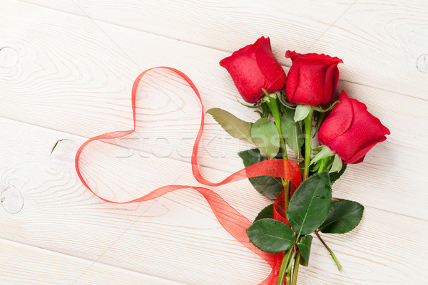 Red roses and heart shape ribbon over wood Stock photo © karandaev