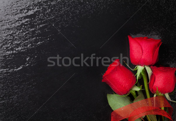 Red roses over black stone background Stock photo © karandaev