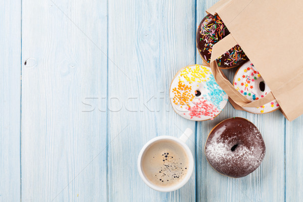 Colorful donuts in paper bag and coffee cup Stock photo © karandaev