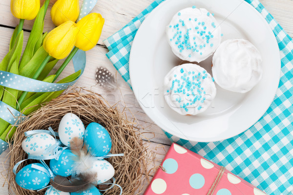 Easter background with blue and white eggs in nest, yellow tulip Stock photo © karandaev