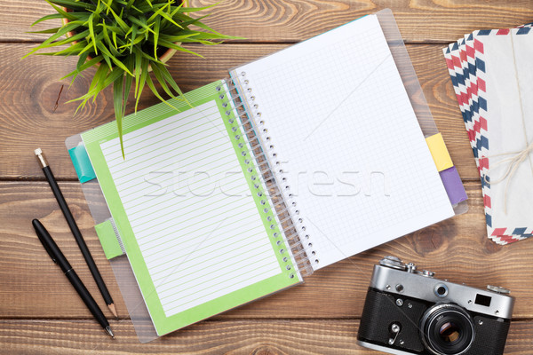Office desk with calendar notepad, camera, supplies and flower Stock photo © karandaev