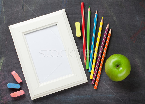 Photo frame and school supplies on blackboard background Stock photo © karandaev