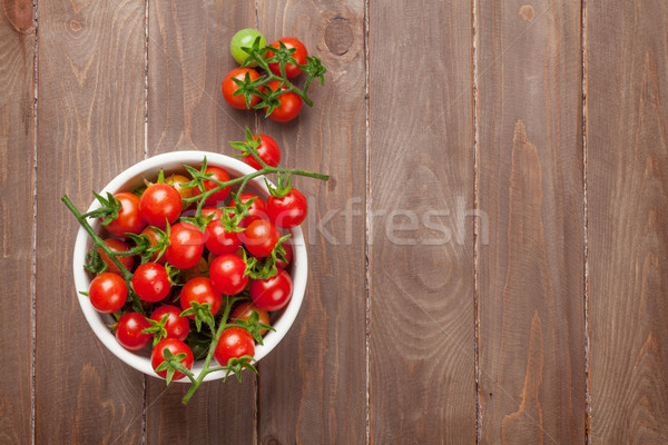 Pomodorini ciotola tavolo in legno top view copia spazio Foto d'archivio © karandaev