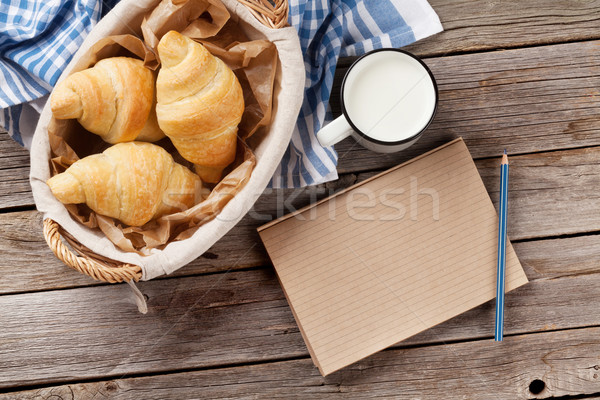 Fresh croissants, milk and notepad Stock photo © karandaev