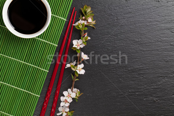 Japanese sushi chopsticks, soy sauce bowl and sakura blossom Stock photo © karandaev