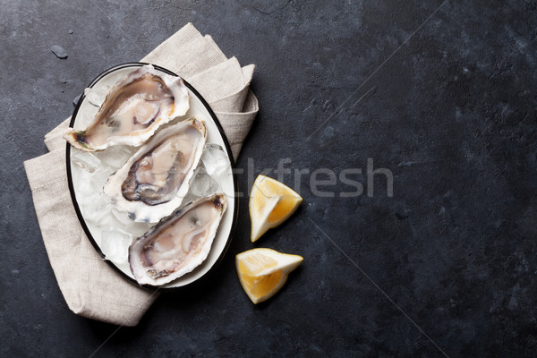 Oysters and lemon over ice Stock photo © karandaev