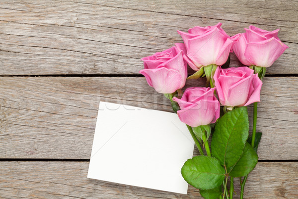 Pink roses bouquet and blank greeting card over wooden table Stock photo © karandaev