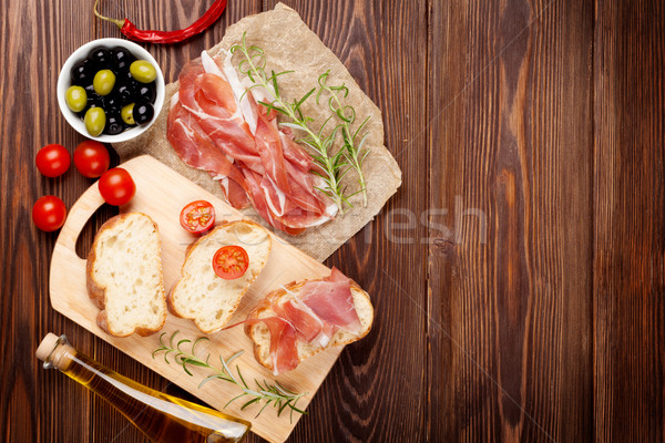 Bruschetta składniki prosciutto oliwek pomidory górę Zdjęcia stock © karandaev