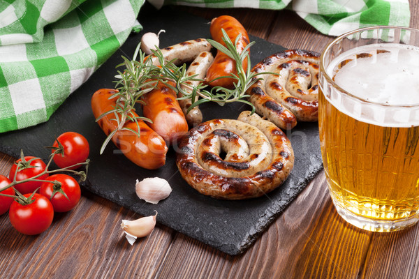 Grelhado salsichas cerveja caneca mesa de madeira comida Foto stock © karandaev