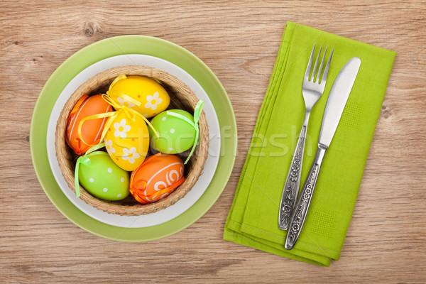 Easter eggs nest on plate over wooden background Stock photo © karandaev