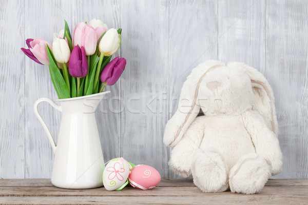 Rabbit toy, easter eggs and colorful tulips Stock photo © karandaev