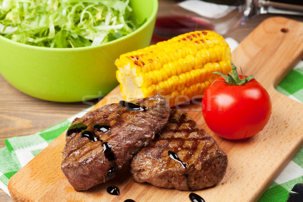 Biefstuk gegrild mais salade rode wijn houten tafel Stockfoto © karandaev