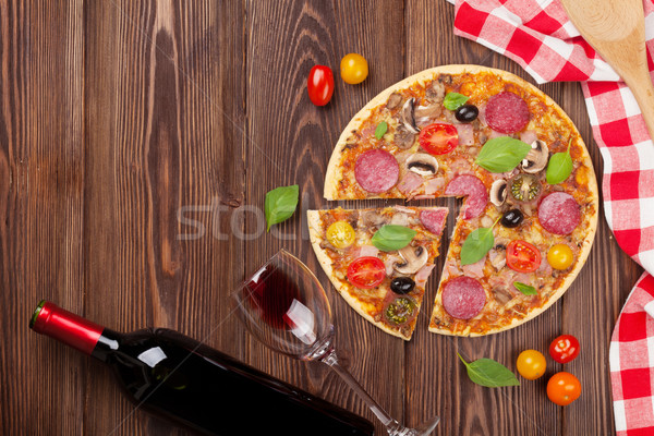 Italian pizza with pepperoni, tomatoes, olives, basil and red wi Stock photo © karandaev