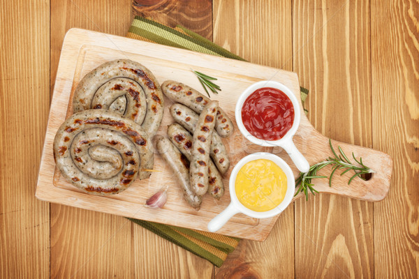 Grilled sausages with ketchup and mustard Stock photo © karandaev