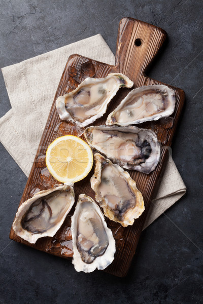 Opened oysters and lemon over ice Stock photo © karandaev