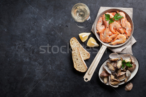 Fresh seafood on stone table. Scallops and shrimps Stock photo © karandaev