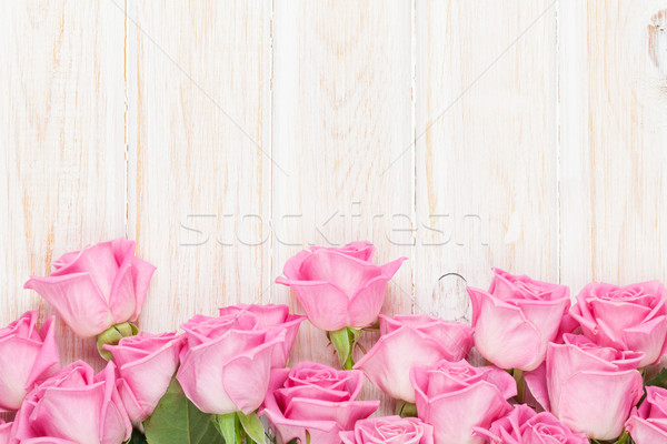Valentines day background with pink roses over wooden table Stock photo © karandaev