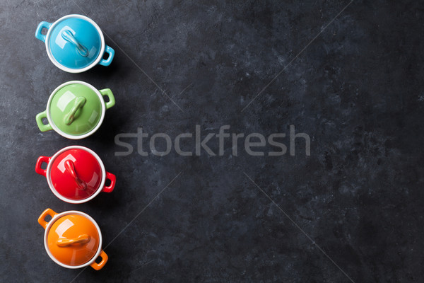 Colorful saucepans on stone table Stock photo © karandaev