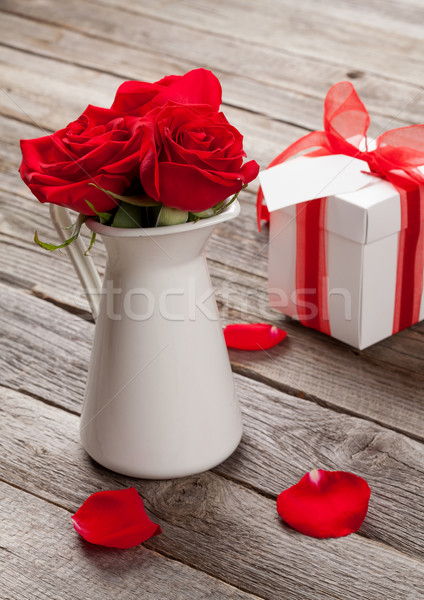 Red rose flowers in pitcher and gift box Stock photo © karandaev