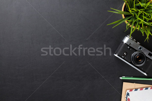 Office desk table with flower, camera and supplies Stock photo © karandaev