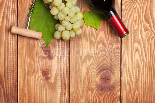 Red wine bottle and bunch of white grapes Stock photo © karandaev