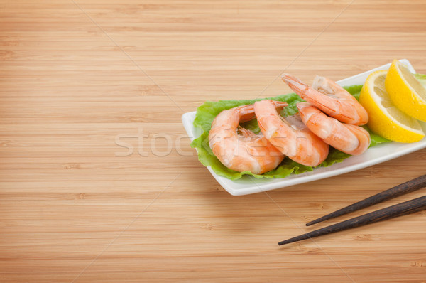 Cooked shrimps with lemon and chopsticks Stock photo © karandaev