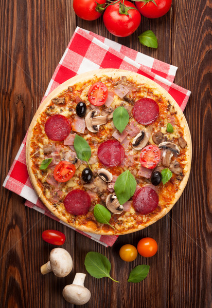 Italian pizza with pepperoni, tomatoes, olives and basil Stock photo © karandaev