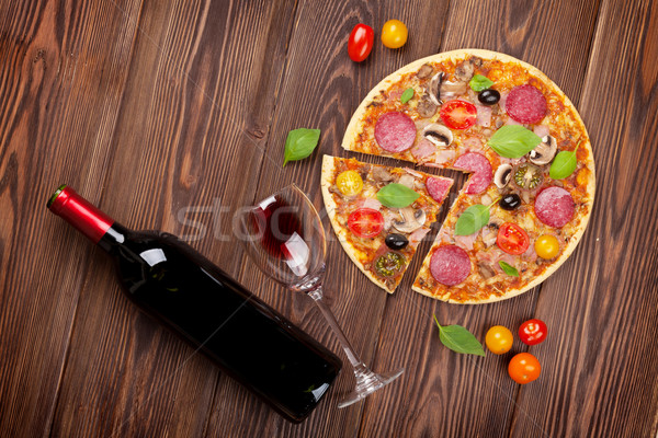 Italian pizza with pepperoni, tomatoes, olives, basil and red wi Stock photo © karandaev