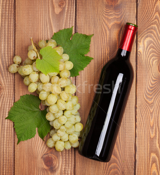 Red wine bottle and bunch of white grapes Stock photo © karandaev