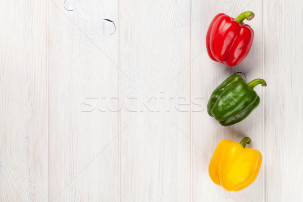 Colorful bell peppers on wooden table Stock photo © karandaev