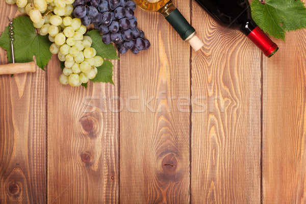 Vermelho vinho branco garrafas monte uvas mesa de madeira Foto stock © karandaev