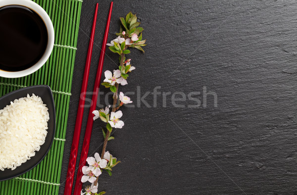 Japanese sushi chopsticks, soy sauce bowl, rice and sakura bloss Stock photo © karandaev