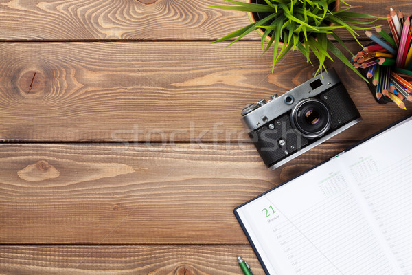 Office desk table with camera, supplies and flower Stock photo © karandaev