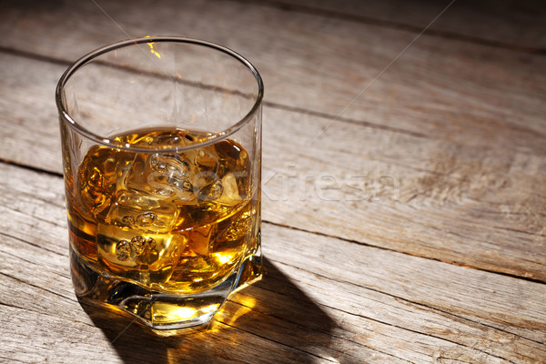 Glass of whiskey with ice on wood Stock photo © karandaev