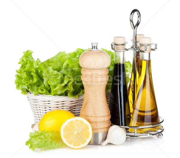 Lettuce in basket with lemon fruits, pepper shaker, olive oil an Stock photo © karandaev