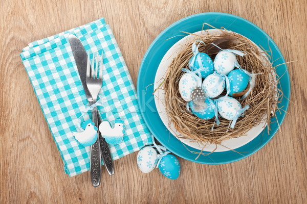 Easter eggs nest on plate over wooden background Stock photo © karandaev