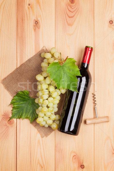 Red wine bottle and bunch of white grapes Stock photo © karandaev