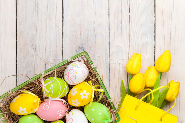 Easter background with colorful eggs and yellow tulips Stock photo © karandaev