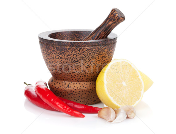 Mortar and pestle with red hot chili pepper and lemon Stock photo © karandaev